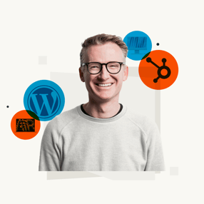 Lachende man met brillen en iconen van WordPress, HubSpot en technologie op de achtergrond.
